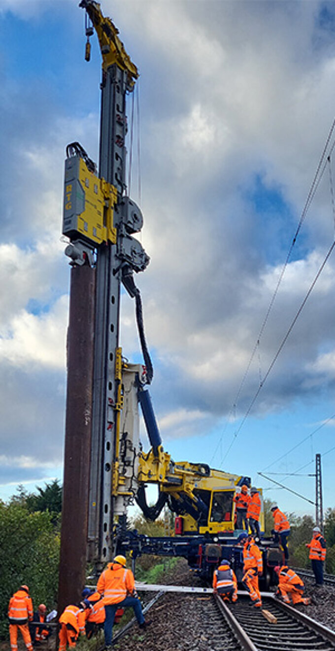 Track foundation train installing a driven pile